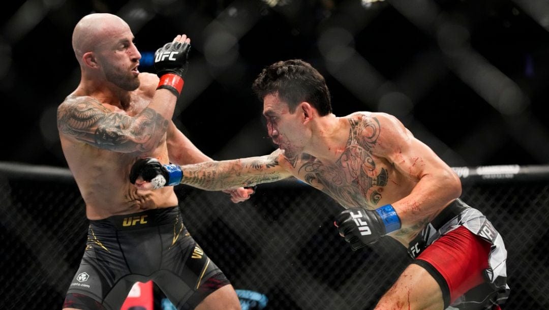 Max Holloway, right, hits Alexander Volkanovski in a featherweight title bout during the UFC 276 mixed martial arts event.