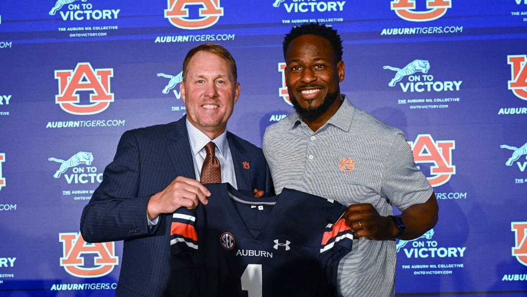 Newly named Auburn football coach Hugh Freeze, left, and Carnell Williams, who will stay on as running backs coach and associate head coach, pose for photos at a news conference Tuesday, Nov. 29, 2022, in Auburn, Ala.