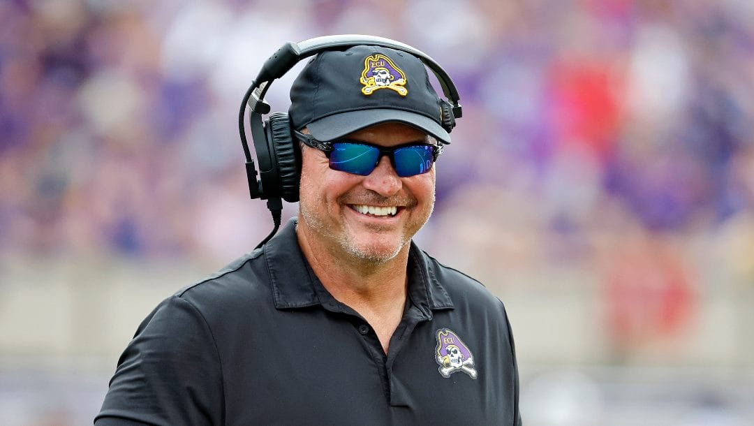East Carolina head coach Mike Houston jokes with an official during the second half of an NCAA college football game against North Carolina State in Greenville, N.C., Saturday, Sept. 3, 2022.
