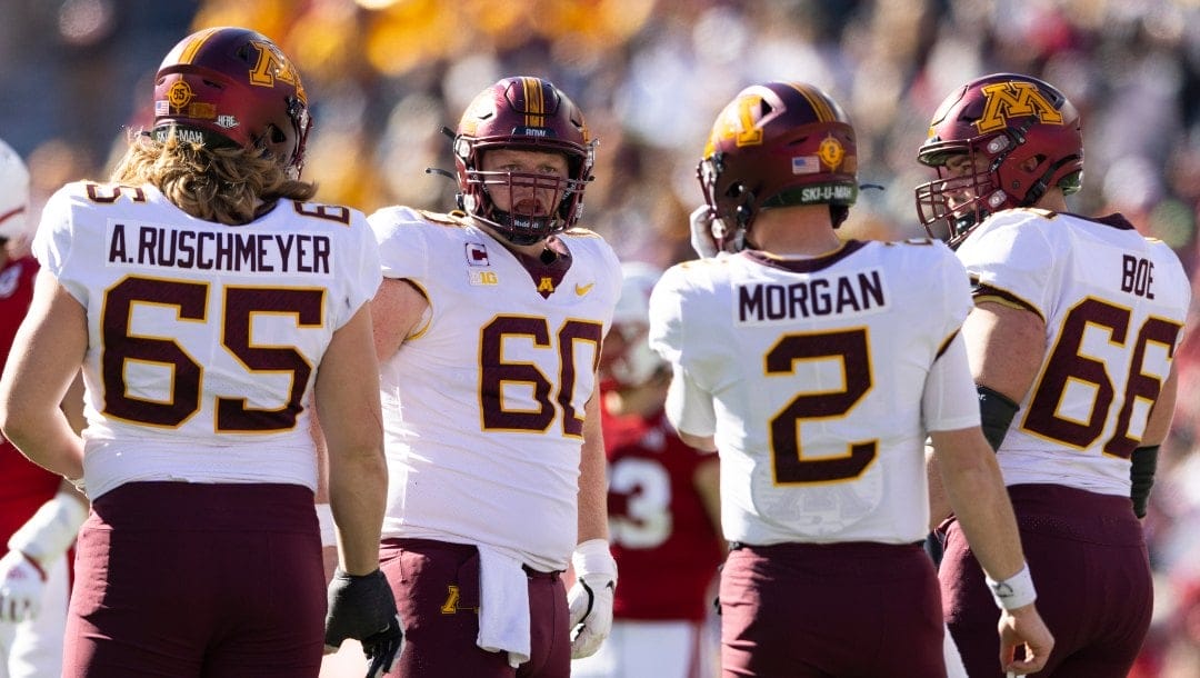 Minnesota offensive lineman John Michael Schmitz (60) chats with teammates Axel Ruschmeyer (65), Tanner Morgan (2) and Nathan Boe (66) between plays against Nebraska during the first half of an NCAA college football game Saturday, Nov. 5, 2022, in Lincoln, Neb.