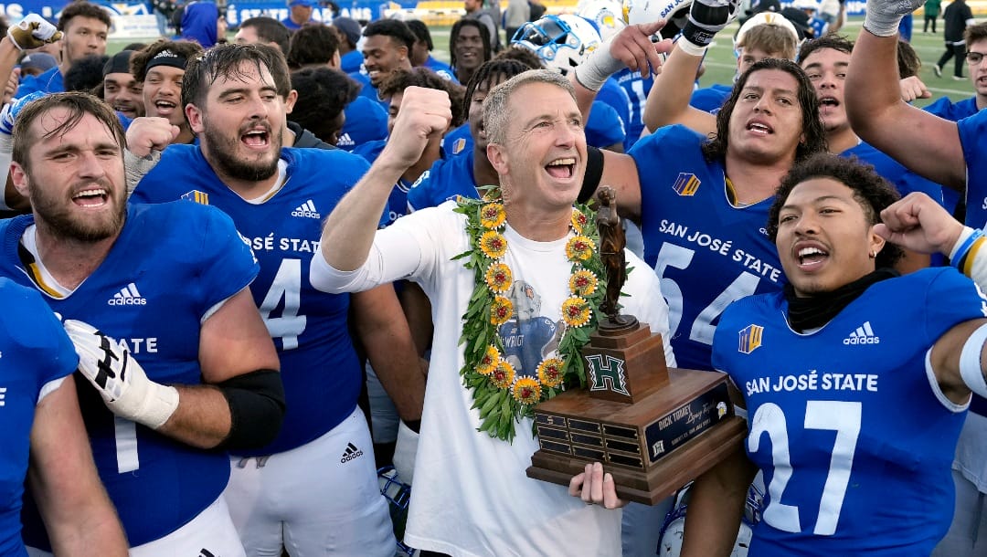 San Jose State head coach Brent Brennan, center, holds the Dick Tomey Legacy trophy after defeating Hawaii 27-14 in an NCAA college football game, Saturday, Nov. 26, 2022, in San Jose, Calif. (AP Photo/Tony Avelar)