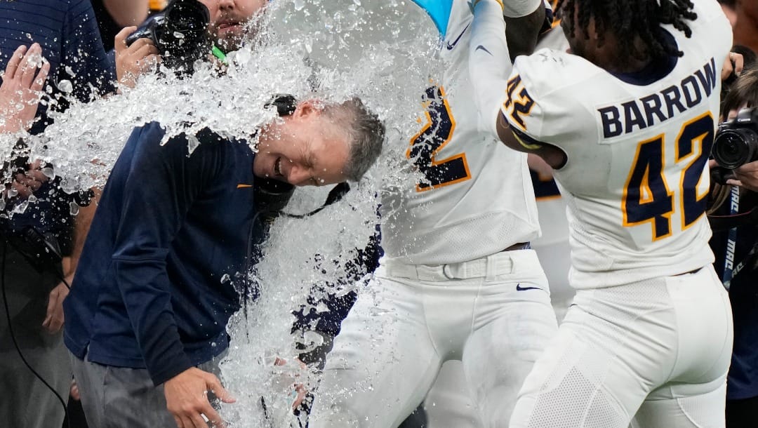 Toledo head coach Jason Candle is doused after the Mid-American Conference championship NCAA college football game against Ohio, Saturday, Dec. 3, 2022, in Detroit. (AP Photo/Carlos Osorio)