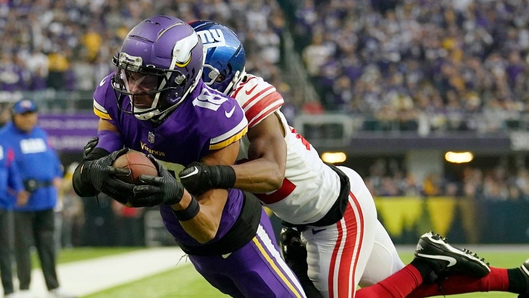 Minnesota Vikings wide receiver Justin Jefferson (18) is takled by New York Giants cornerback Adoree' Jackson (22) during the first half of an NFL wild-card football game Sunday, Jan. 15, 2023, in Minneapolis. (AP Photo/Abbie Parr)