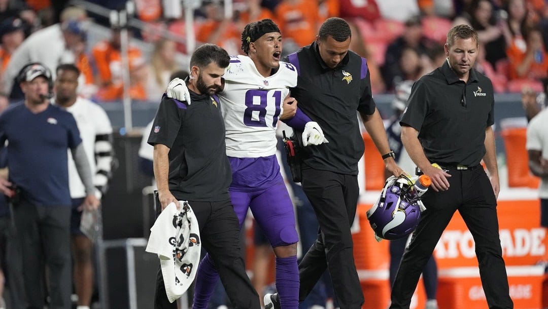 Minnesota Vikings wide receiver Bisi Johnson (81) is helped off the field during an NFL preseason football game, Aug. 27, 2022, in Denver.