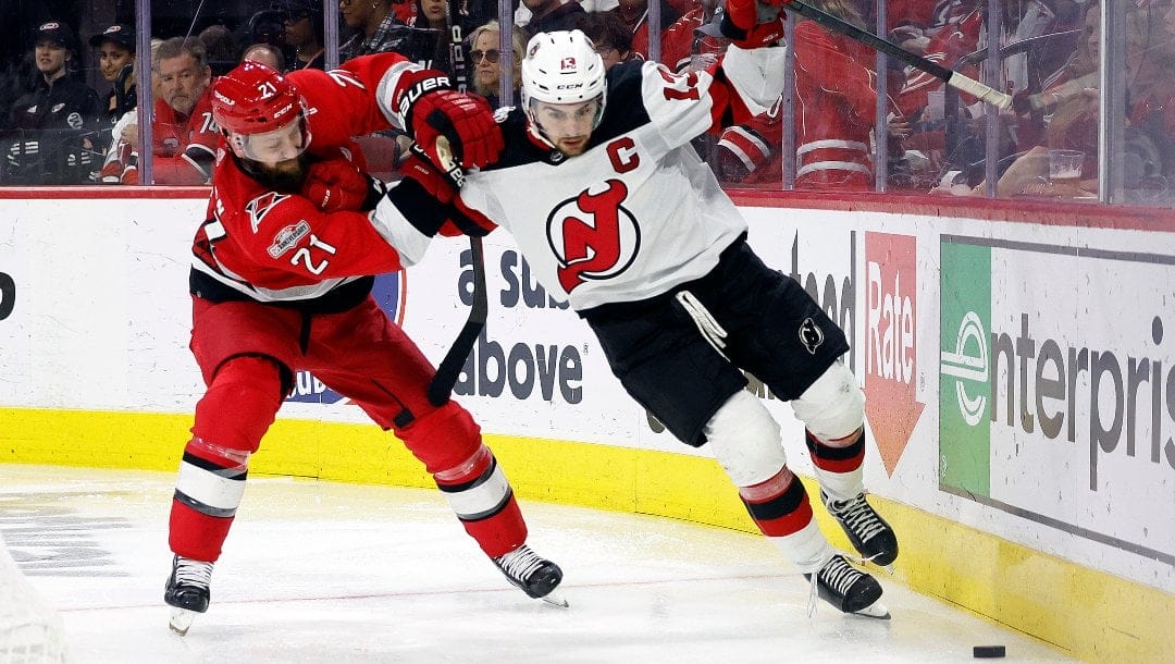 New Jersey Devils' Nico Hischier (13) works agains Carolina Hurricanes' Derek Stepan (21) during the third period of Game 5 of an NHL hockey Stanley Cup second-round playoff series in Raleigh, N.C., Thursday, May 11, 2023.