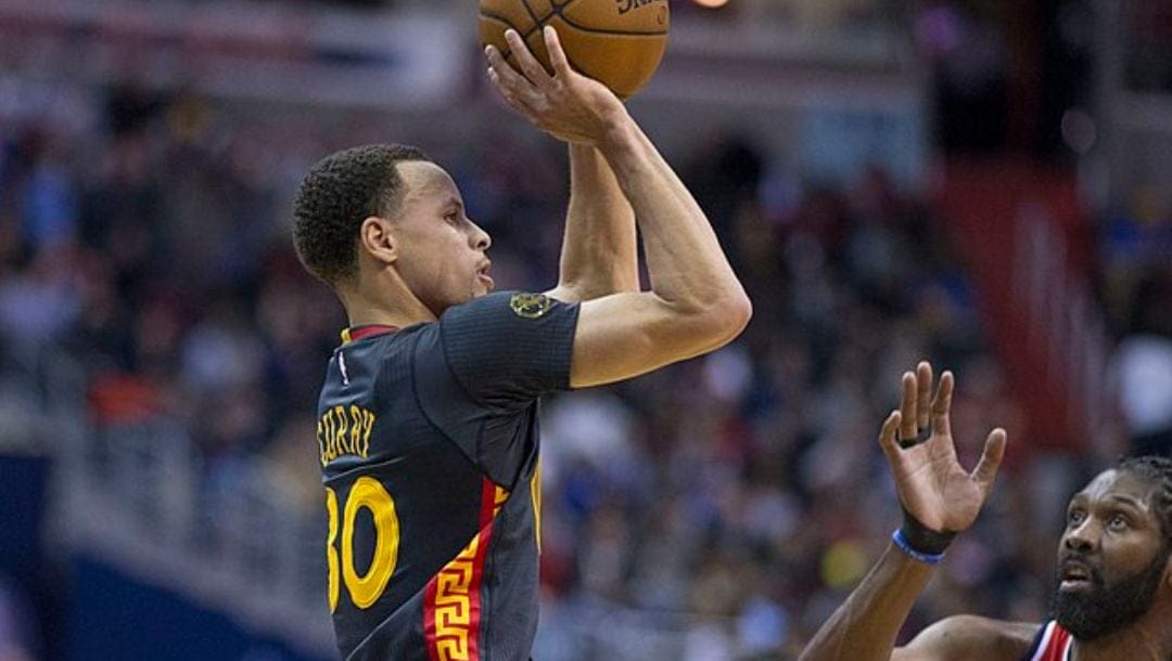 Stephen Curry shoots over Nene during an NBA game between the Golden State Warriors and Washington Wizards in 2015.