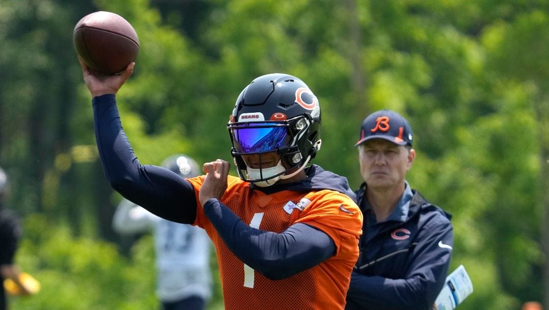 Chicago Bears quarterback Justin Fields works on the field as head coach Matt Eberflus looks on during NFL football practice in Lake Forest, Ill., Wednesday, June 7, 2023.