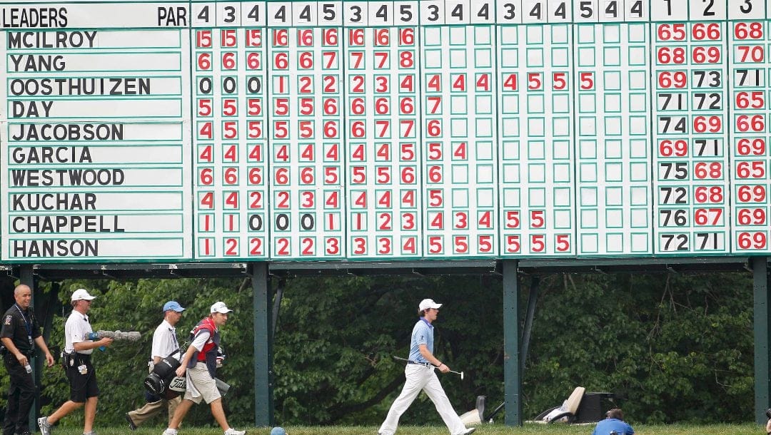 Rory McIlroy, of Northern Ireland, walks past the leaderboard on the 10th green during the final round of the U.S. Open Championship golf tournament in Bethesda, Md., Sunday, June 19, 2011.