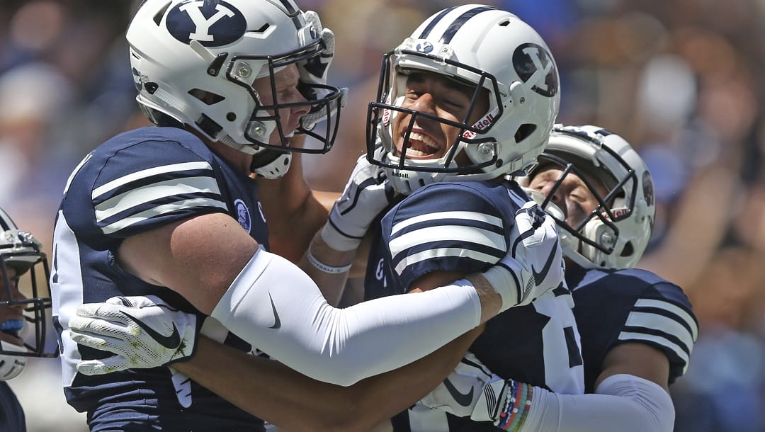 BYU wide receiver Neil Pau'u, center, celebrates his touchdown with teammates Matt Bushman, left, and Inoke Lotulelei, right, in the first half of an NCAA college football game against Portland State, Saturday, Aug. 26, 2017, in Provo, Utah.