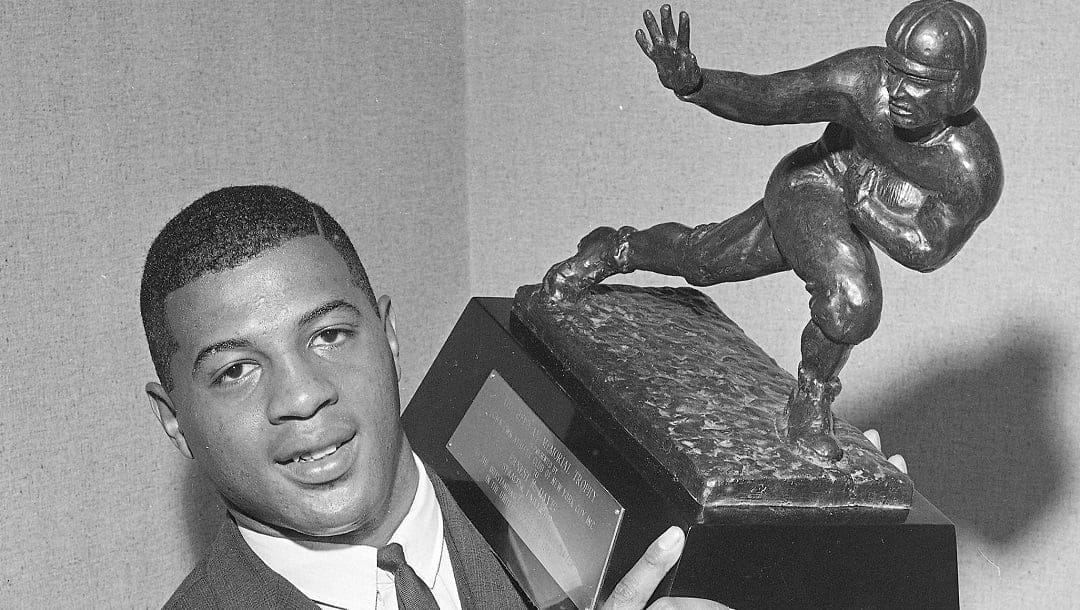 In this Dec. 6, 1961 file photo, Syracuse university football player Ernie Davis holds his Heisman Trophy at the Downtown Athletic club in New York. A football taken from the upstate New York grave of Davis has been found. The football was discovered missing from its display case on March 15. The ball has disappeared several times previously, only to turn up later on the cemetery grounds. Davis was an All-American at Syracuse University and the first black player to win the Heisman.