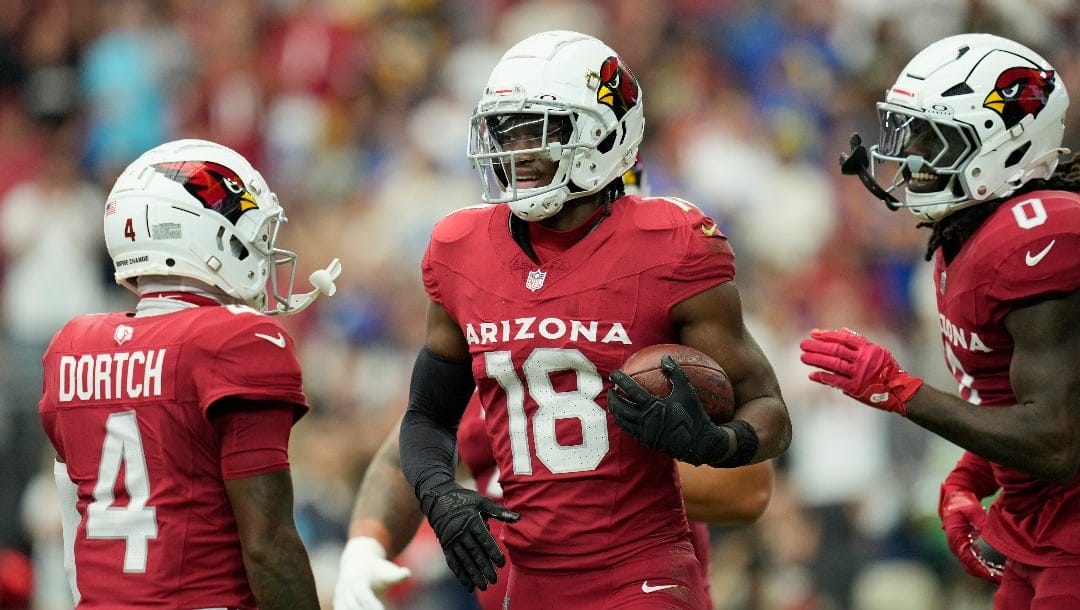 Arizona Cardinals wide receiver Marvin Harrison Jr. (18) celebrates his touchdown catch against the Los Angeles Rams with Cardinals wide receivers Greg Dortch (4) and Zach Pascal (0) during the first half of an NFL football game Sunday, Sept. 15, 2024, in Glendale, Ariz. The Cardinals won 41-10. (AP Photo/Ross D. Franklin)