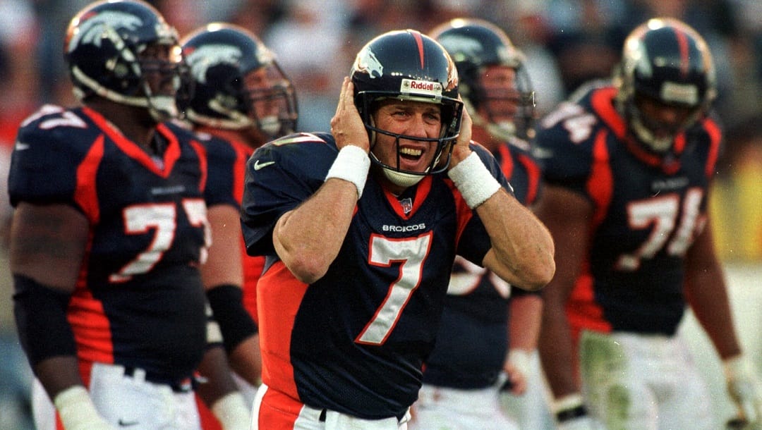 Denver Broncos quarterback John Elway (7) holds his hands over his helmet as he strains to hear the next play on his radio during the Broncos 40-14 victory over the Oakland Raiders at Mile High Stadium in Denver on Sunday, Nov. 22, 1998. The win extended the Broncos record to 11-0.