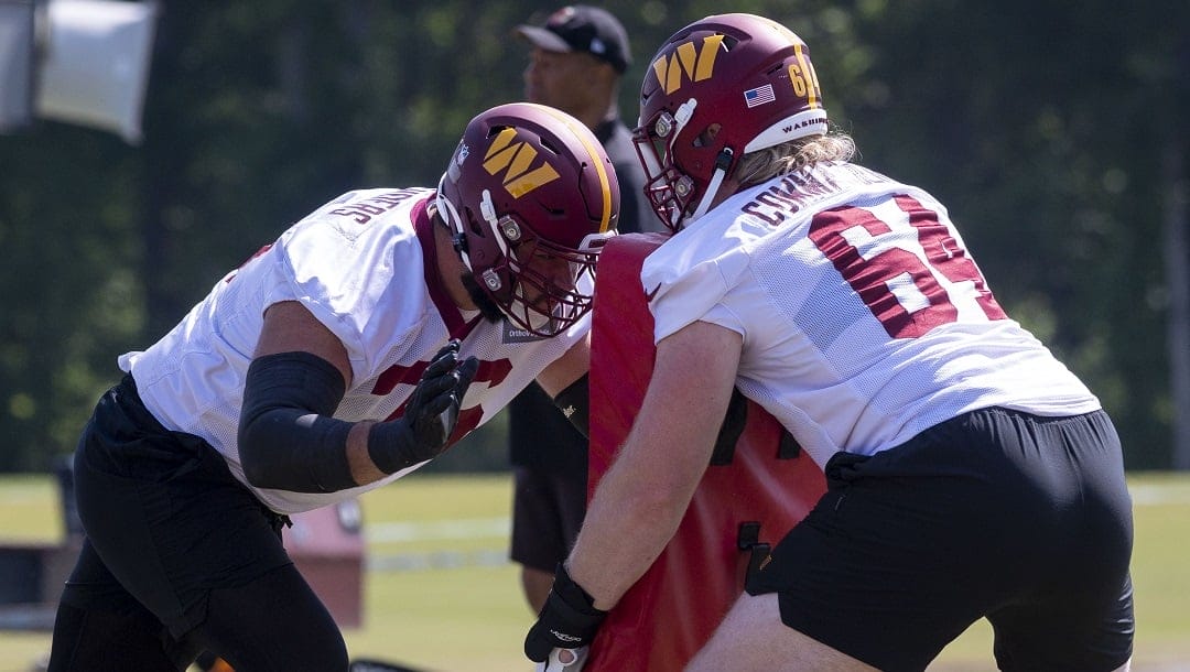 Washington Commanders defensive tackle David Bada (64), right, and offensive tackle Sam Cosmi (76) take part in the team's NFL football practice in Ashburn, Va., Wednesday, May 31, 2023.