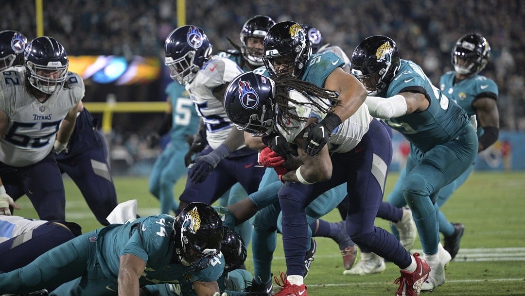 Tennessee Titans running back Derrick Henry (22) is stopped for no gain by Jacksonville Jaguars defensive tackle Corey Peters (98) during the second half of an NFL football game, Saturday, Jan. 7, 2023, in Jacksonville, Fla.