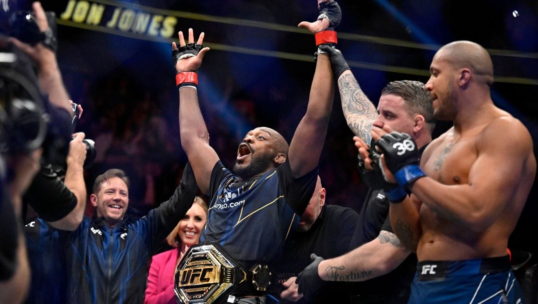 Jon Jones, center, celebrates after defeating Ciryl Gane in a UFC 285 mixed martial arts heavyweight title bout.