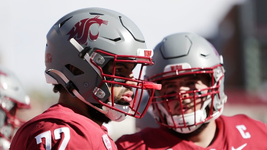 Washington State offensive lineman Abraham Lucas, left, and offensive lineman Liam Ryan speak during the first half of an NCAA college football game against Oregon State, Saturday, Oct. 9, 2021, in Pullman, Wash.