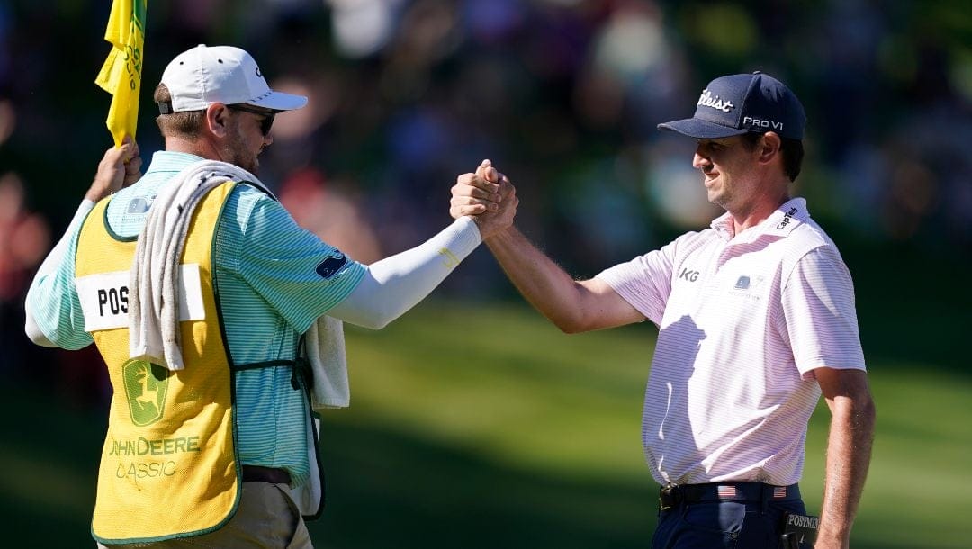 J.T. Poston, right, celebrates with his caddie on the 18th green after winning the John Deere Classic golf tournament, Sunday, July 3, 2022, at TPC Deere Run in Silvis, Ill.