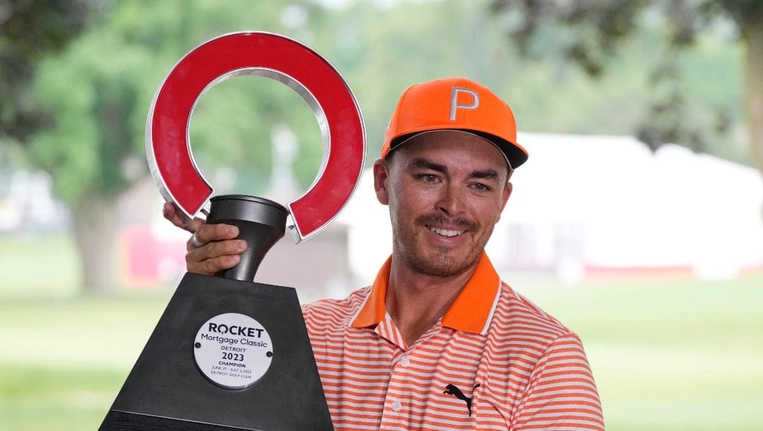 Rickie Fowler holds the winner's trophy after winning on the first play-off hole on the 18th green during the final round of the Rocket Mortgage Classic golf tournament at Detroit Country Club, Sunday, July 2, 2023, in Detroit.