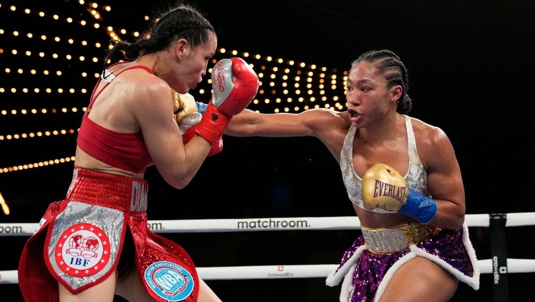 Alycia Baumgardner, right, punches Elhem Mekhaled, of France, during the third round of a women's super featherweight championship.