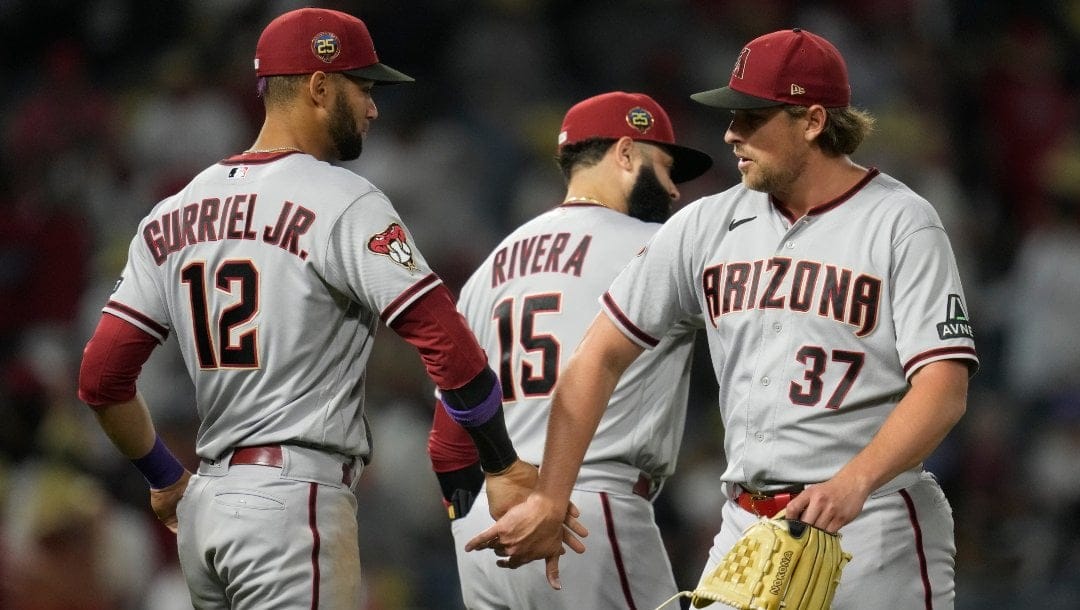 Arizona Diamondbacks designated hitter Lourdes Gurriel Jr. (12), third baseman Emmanuel Rivera (15) and relief pitcher Kevin Ginkel (37) celebrate after a 6-2 win over the Los Angeles Angels in a baseball game in Anaheim, Calif., Friday, June 30, 2023.