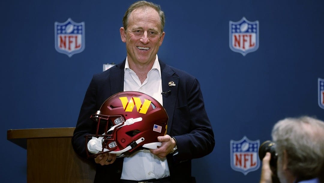 Josh Harris, leader of a group buying the Washington Commanders, poses with a team helmet after NFL owners voted to approve the sale in Bloomington, Minn., Thursday, July 20, 2023.