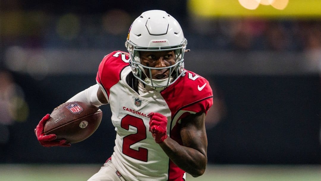 Cardinals player number 2 running with NFL game ball in hand.