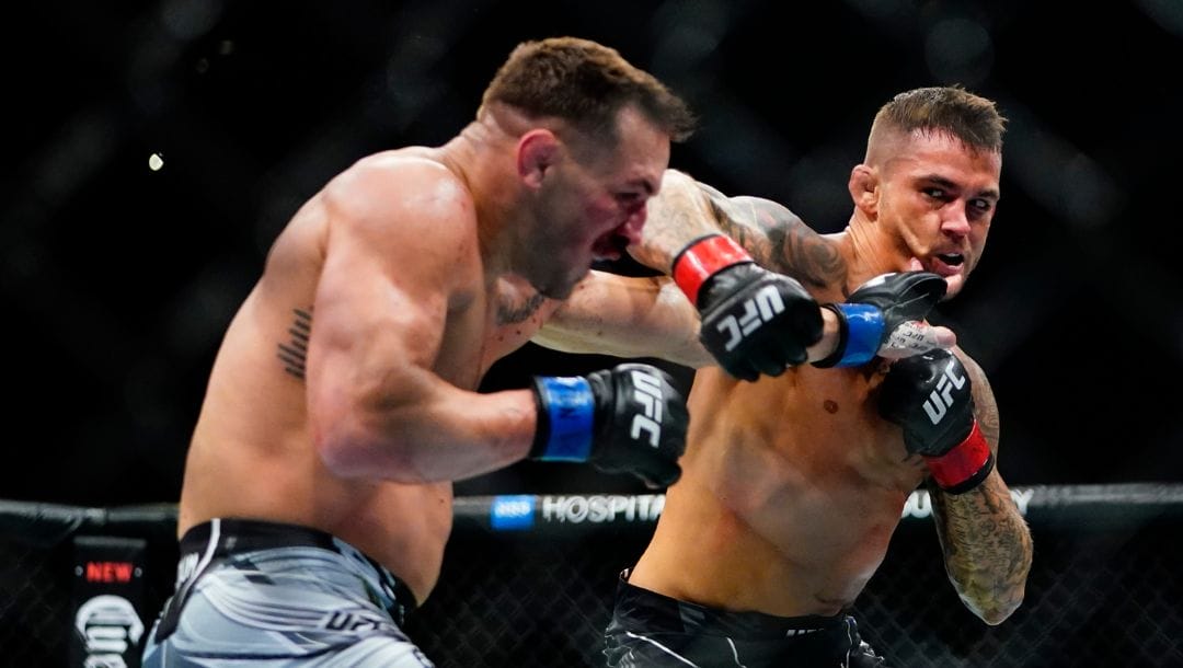 Dustin Poirier, right, punches Michael Chandler during the first round of a lightweight bout at the UFC 281.