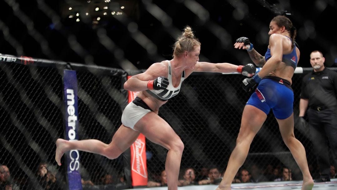 Holly Holm, left, fights Germaine de Randamie, of the Netherlands, right, during a women's featherweight championship.
