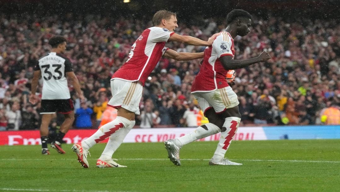 Arsenal's Bukayo Saka, right, celebrates after scoring his side's first goal during the English Premier League soccer match between Arsenal and Fulham at Emirates stadium in London, Saturday, Aug. 26, 2023.