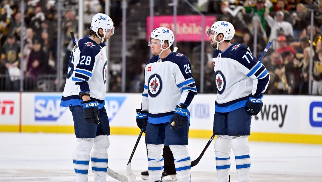 Winnipeg Jets center Kevin Stenlund (28), center Karson Kuhlman (20) and defenseman Kyle Capobianco (77) talk during a break in the action against the Vegas Golden Knights during the second period of Game 5 of an NHL hockey Stanley Cup first-round playoff series Thursday, April 27, 2023, in Las Vegas.