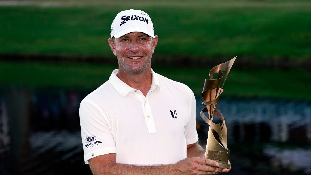Lucas Glover holds the winner's trophy after winning the St. Jude Championship golf tournament Sunday, Aug. 13, 2023, in Memphis, Tenn.