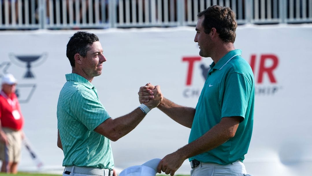 Rory McIlroy, of Northern Ireland, left and Scottie Scheffler speak after their round on the 18th green during the final round of the Tour Championship golf tournament at East Lake Golf Club, Sunday, Aug. 28, 2022, in Atlanta.