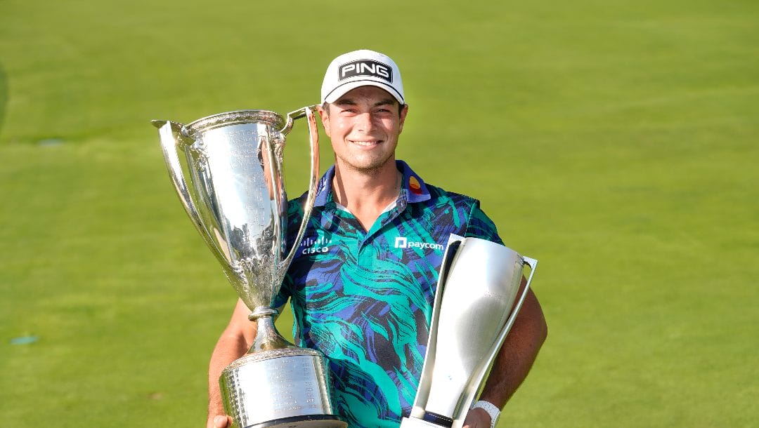 Viktor Hovland holds the Western Golf Association Trophy, left, and the BMW Championship Trophy after winning in the final round of the BMW Championship golf tournament, Sunday, Aug. 20, 2023, in Olympia Fields, Ill.