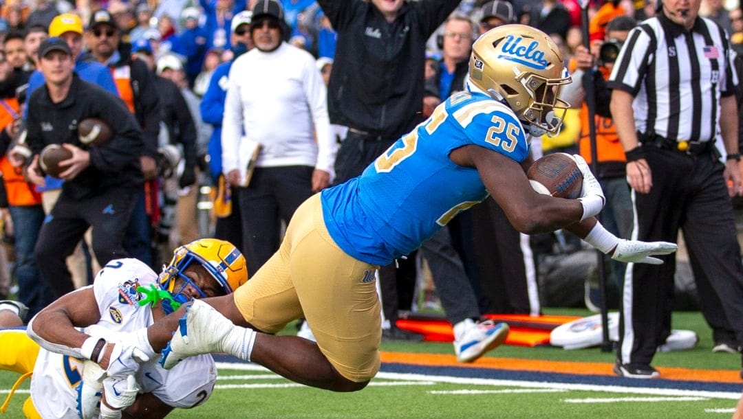 UCLA running back T.J. Harden (25) dives into the end zone for a touchdown as Pittsburgh defensive back P.J. O'Brien (22) fails to tackle him during the second half of the Sun Bowl NCAA college football game, Friday, Dec. 30, 2022 in El Paso, Texas. (AP Photo/Andres Leighton)