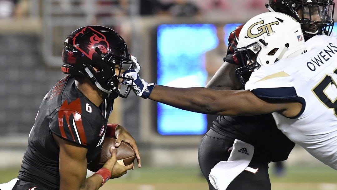 Georgia Tech defensive lineman Antwan Owens (89) grabs Louisville quarterback Jordan Travis (6) by the face mask during the second half of an NCAA college football game Friday, Oct. 5, 2018, in Louisville, Ky. Georgia Tech won 66-31.