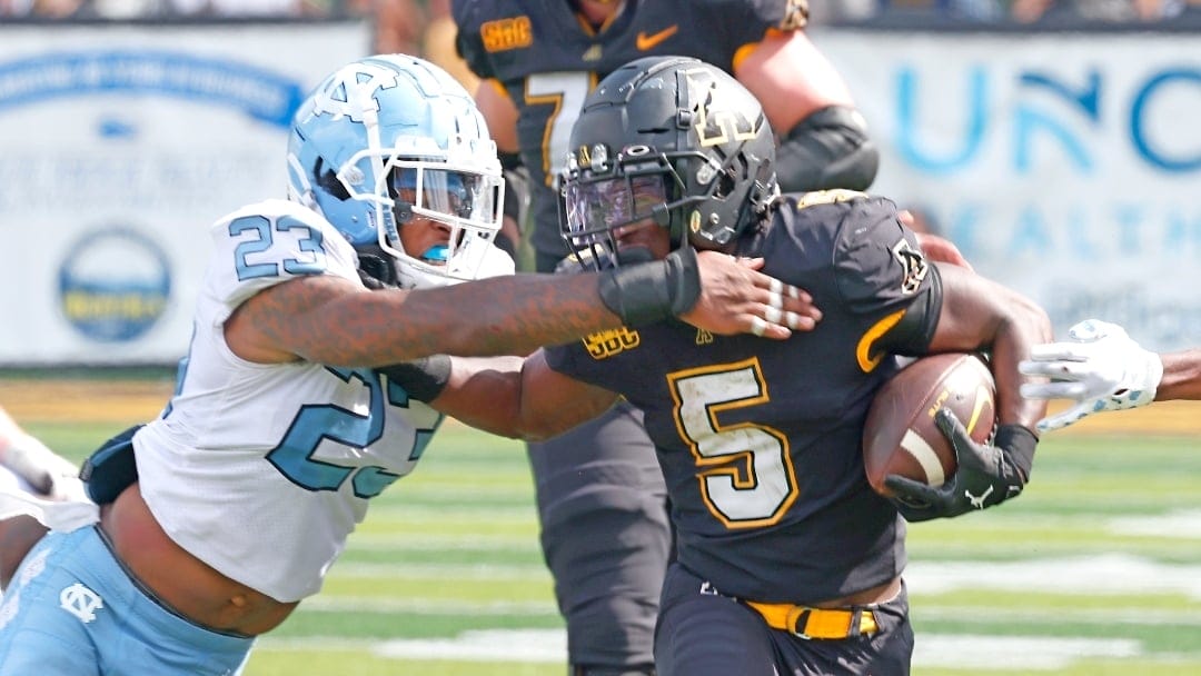 Appalachian State running back Nate Noel (5) runs past North Carolina linebacker Power Echols (23) during the second half of an NCAA college football game, Saturday Sept. 3, 2022, in Boone, N.C. (AP Photo/Reinhold Matay)