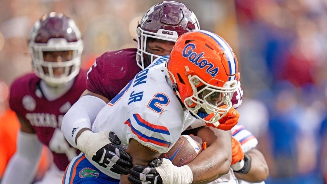 Texas A&M linebacker Edgerrin Cooper (45) wraps up Florida running back Montrell Johnson Jr. (2) for a two-yard loss during the first quarter of an NCAA college football game Saturday, Nov. 5, 2022, in College Station, Texas. (AP Photo/Sam Craft)
