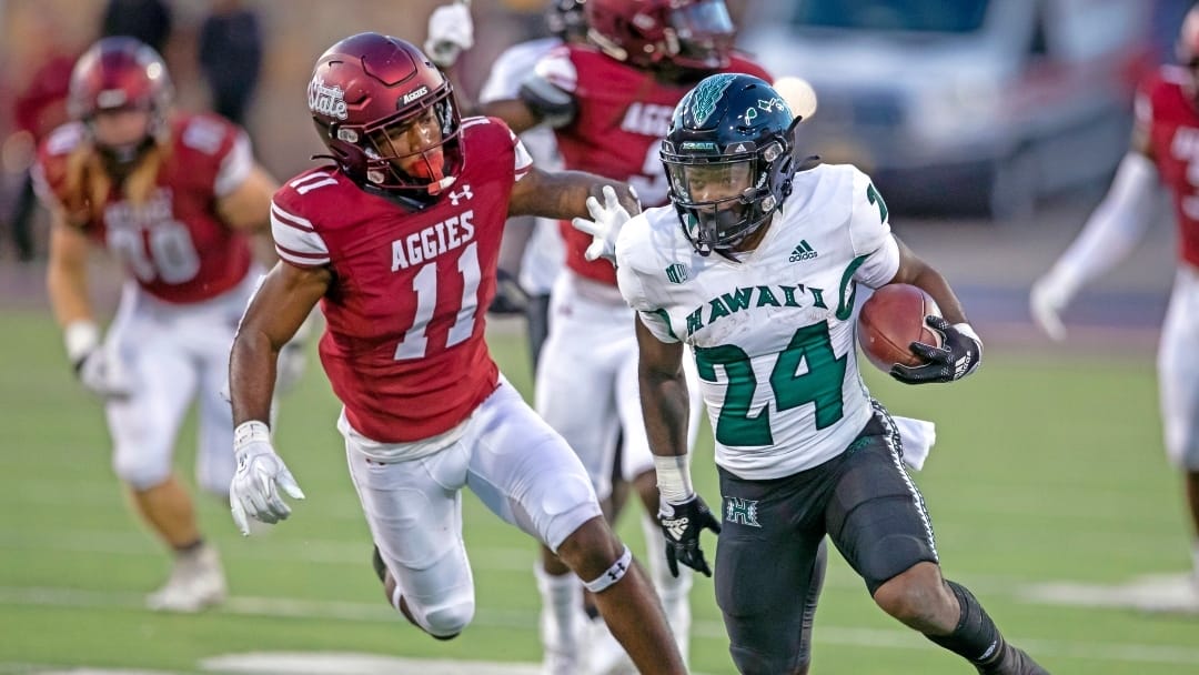 Hawaii running back Tylan Hines (24) runs for yardage followed by New Mexico State defensive back Dylan Early (11) during the first half of an NCAA college football game in Las Cruces, N.M., Saturday, Sept. 24, 2022.