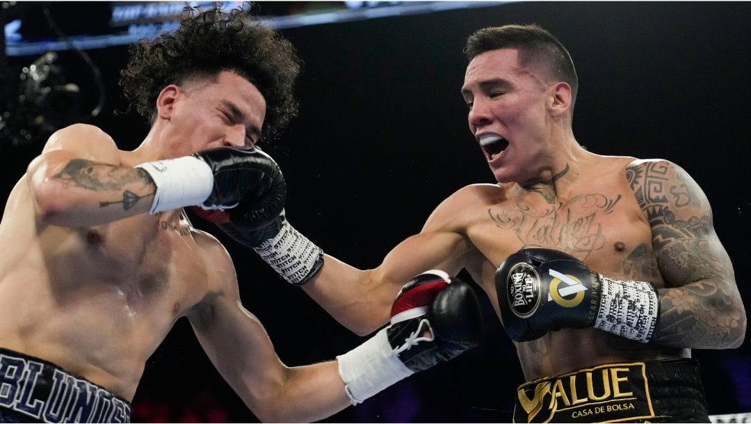 Adam Lopez, left, fights Oscar Valdez in a junior lightweight boxing match Saturday, May 20, 2023, in Las Vegas.