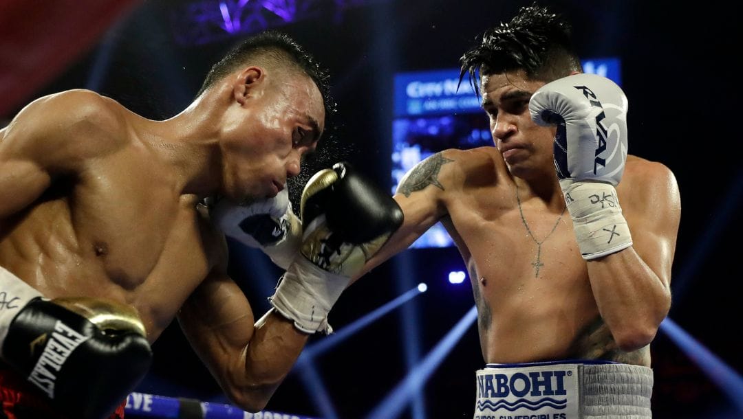 Emanuel Navarrete, of Mexico, right, punches Jeo Santisima, of the Philippines, during their super bantamweight boxing match.