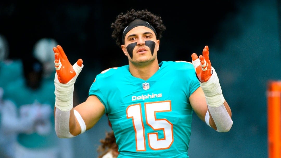 Miami Dolphins linebacker Jaelan Phillips (15) gestures as he is introduced to the fans and runs onto the field before an NFL football game against the Green Bay Packers, Sunday, Dec. 25, 2022, in Miami Gardens, Fla. (AP Photo/Doug Murray)