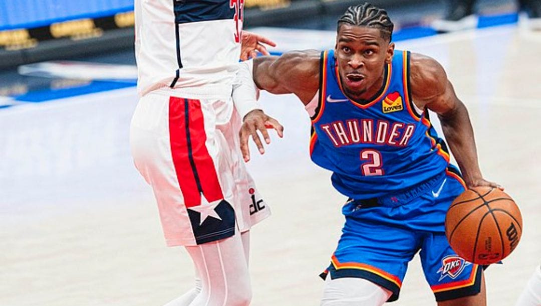 Shai Gilgeous-Alexander of the Oklahoma City Thunders drives to the basket against Kyle Kuzma of the Washington Wizards.