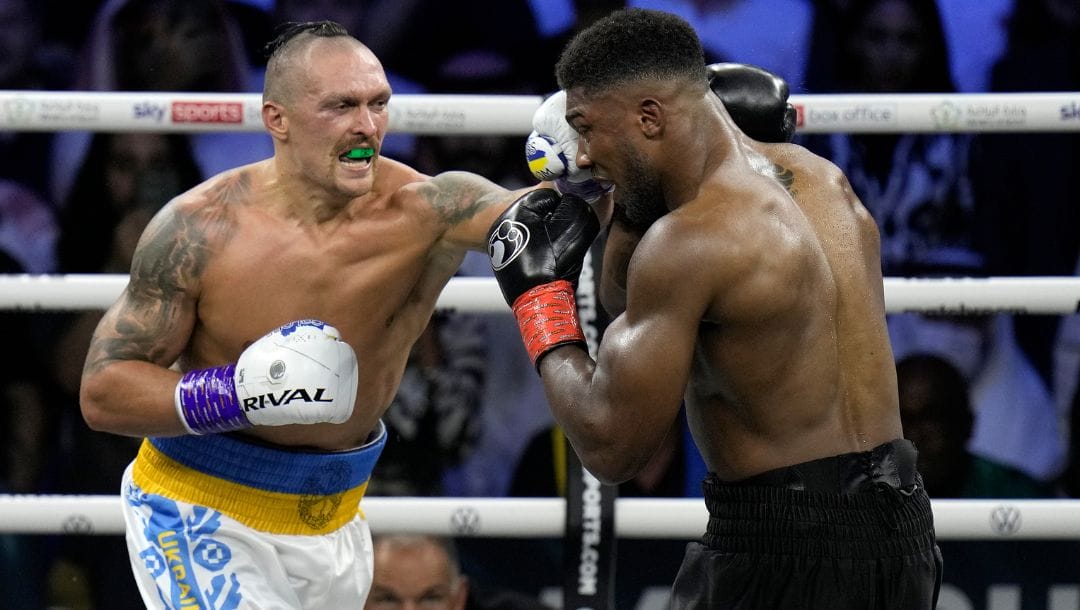 Britain's Anthony Joshua, right, takes a blow from Ukraine's Oleksandr Usyk during their world heavyweight title fight.