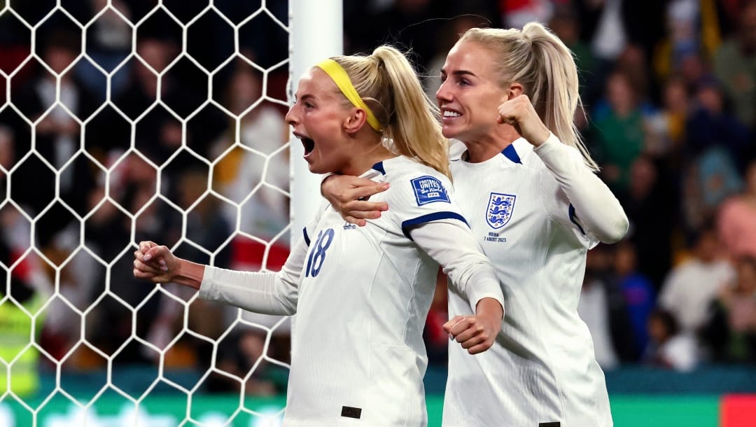 England's Chloe Kelly, left, celebrates with England's Alex Greenwood after scoring the last goal during a penalty shootout during the Women's World Cup round of 16 soccer match between England and Nigeria in Brisbane, Australia, Monday, Aug. 7, 2023. (AP Photo/Tertius Pickard)