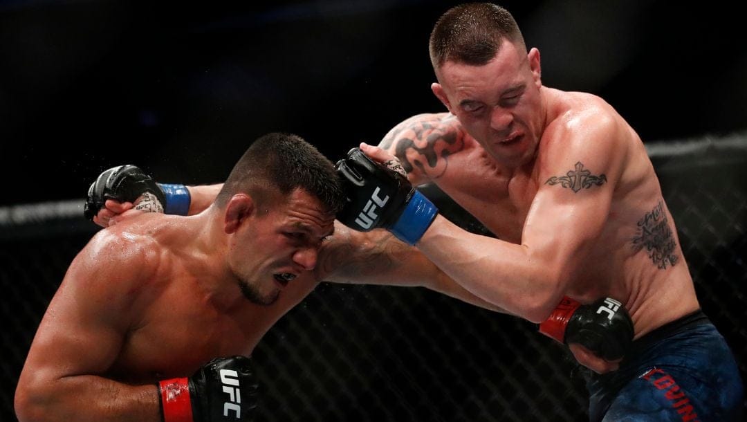 Rafael Dos Anjos, left, and Colby Covington exchange punches during their welterweight UFC 225 mixed martial arts bout.