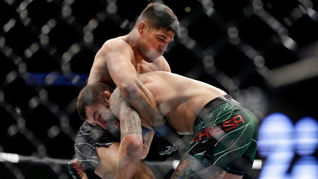 Vicente Luque, top, attempts a take down of Michael Chiesa during their welterweight mixed martial arts bout at UFC 265.