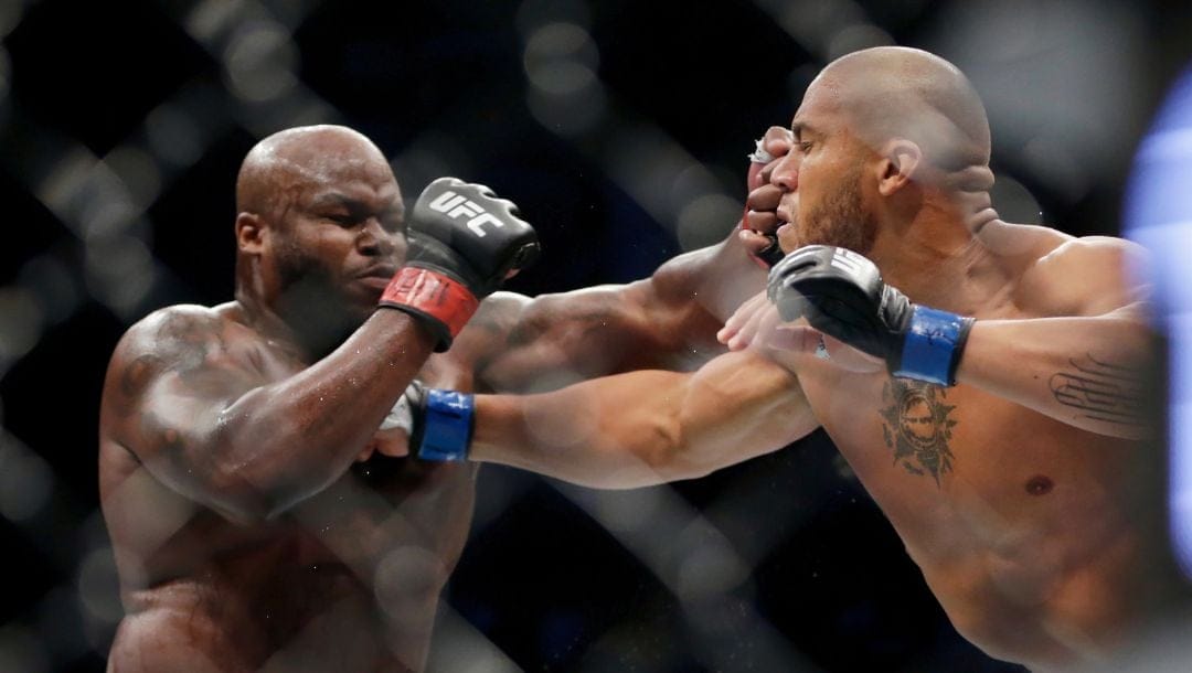 Derrick Lewis, left, takes a punch from Ciryl Gane during their interim heavyweight mixed martial arts title bout at UFC 265.