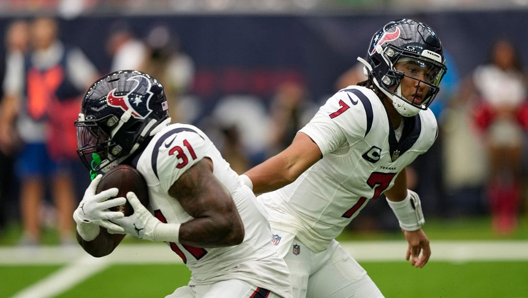 Houston Texans quarterback C.J. Stroud (7) hands off to running back Dameon Pierc (31) in the first half of an NFL football game against the Indianapolis Colts in Houston, Sunday, Sept. 17, 2023.