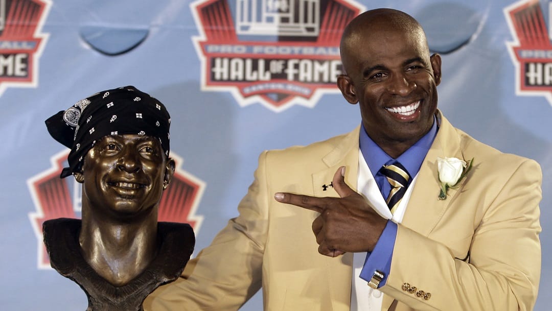 Deion Sanders poses with a bust of himself during the induction ceremony at the Pro Football Hall of Fame, Saturday, Aug. 6, 2011, in Canton, Ohio.