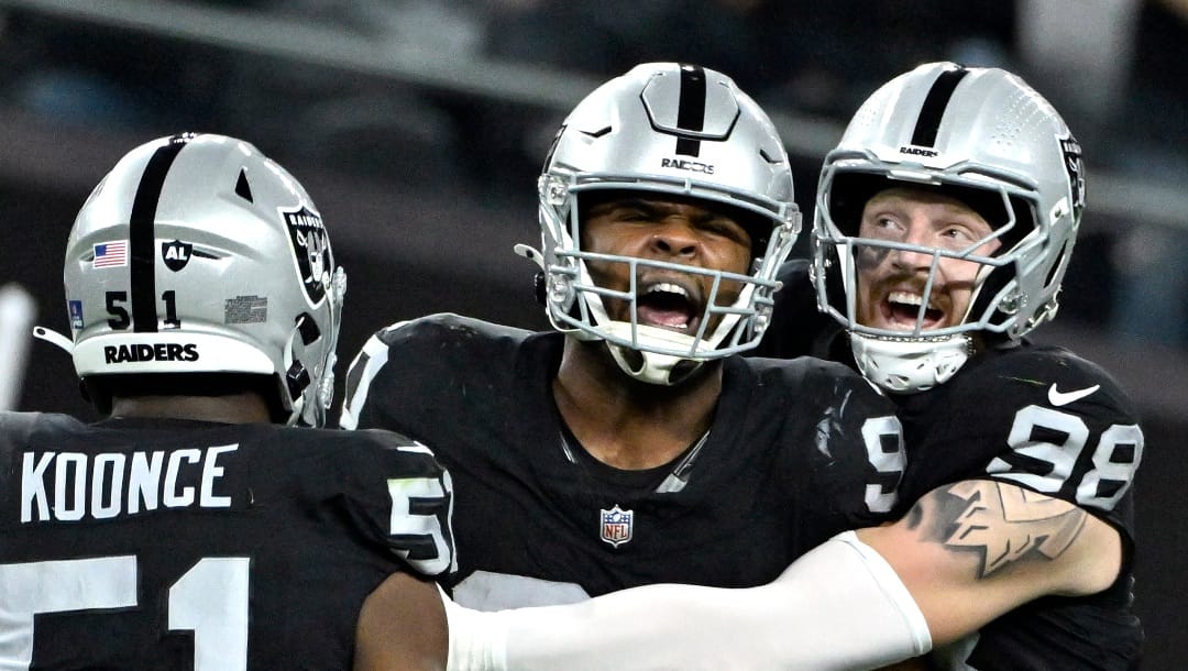 Las Vegas Raiders defensive end Malcolm Koonce (51), defensive tackle Jerry Tillery (90) and defensive end Maxx Crosby (98) celebrate after a tackle against the Los Angeles Chargers an NFL football game, Thursday, Dec. 14, 2023, in Las Vegas. (AP Photo/David Becker)